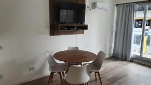 布宜诺斯艾利斯Nuevo y luminoso departamento en Palermo的配有电视的客房内的桌椅