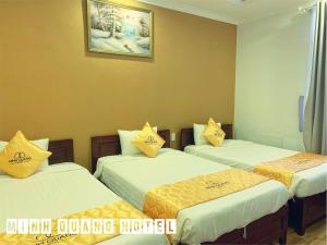 潘郎Khách sạn Minh Quang的带3张黄色枕头的床的房间