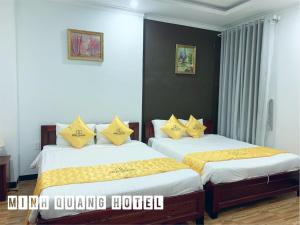 潘郎Khách sạn Minh Quang的一间卧室配有两张带黄色枕头的床