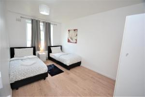 伦敦Beautiful London 2 Bedroom Flat near Finsbury Park的一间卧室设有两张床和窗户。