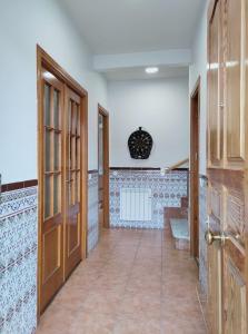 PolánCasa Rosales Toledo a 10 minutos de Puy du Fou的走廊设有木门,铺有瓷砖地板