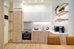 雅典Eos Residence的厨房配有白色橱柜和炉灶烤箱。