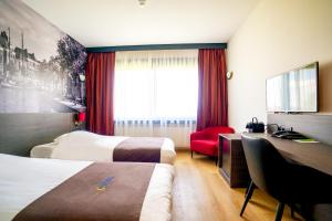 格罗宁根巴斯琛哥罗普酒店的酒店客房配有两张床和一张书桌