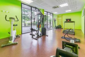 波城All Suites Pau – Zénith的健身房设有绿色的墙壁和跑步机