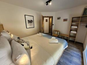 克松吕-隆日梅La cabane des écureuils的一间卧室配有一张大床和毛巾