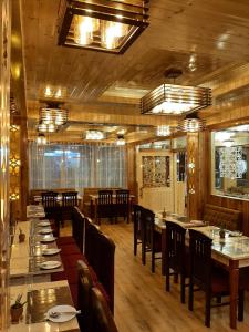 甘托克Hotel Zingkham Residency的餐厅铺有木地板,配有桌椅