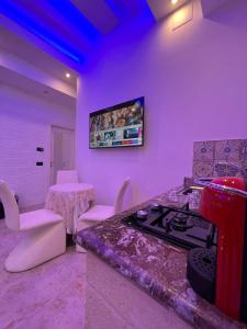 法萨诺GianLuis Luxury Suites的紫色的客房设有1间带炉灶和桌子的厨房