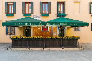 威尼斯圣塔马丽娜酒店的大楼前的绿色雨伞酒店