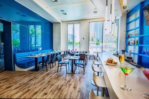 哈兰代尔海滩Ocean View 2BR 2BTH Hallandale Beach Miami Ft Lauderdale的餐厅拥有蓝色的墙壁和桌椅