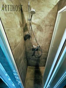 帕内韦日斯Artihost的浴室里的一个淋浴间,上面有文字制品