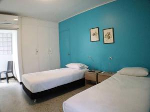 卡利Casa Mandala en Los Cristales的酒店客房设有两张床和蓝色的墙壁。