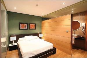 卡萨斯-伊瓦涅斯Hospedium Apartamentos Cañitas Maite Familiar的卧室设有一张白色大床和绿色的墙壁