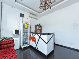 瓜拉丁加奴Super OYO 90364 Hotel Gemilang的客厅配有冰箱和红色沙发