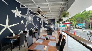曼努埃尔安东尼奥La Posada Jungle Hotel的餐厅设有木桌和椅子,墙上挂着星星。