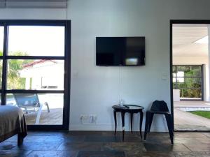 乌瑞基尼Chambre SOKA的卧室配有桌子和墙上的电视。