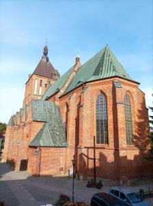 科沙林Przy Katedrze的一座大型红砖教堂,设有绿色屋顶