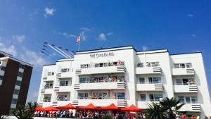 伯恩茅斯坎伯兰海洋休闲酒店的上面有旗帜的白色建筑