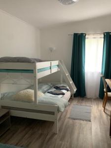 ZsombóArvisura Vendégházak family friendly transit apartments的一间卧室配有带梯子的双层床