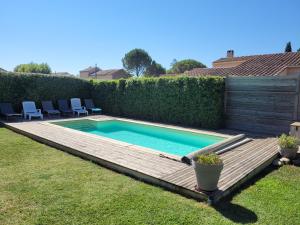 艾居厄河畔卡马勒Villa de la Capèra的一个带木甲板的庭院内的游泳池