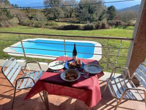 Parada de AchasLobetios - Casa rural的阳台上的桌子上放着一瓶葡萄酒和食物