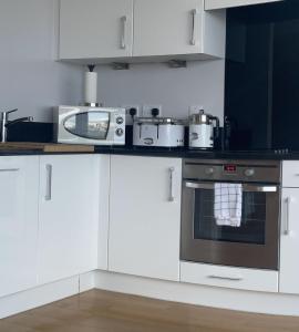 查塔姆Luxury 8th Floor Apartment with Stunning Views的厨房配有白色橱柜和炉灶烤箱。