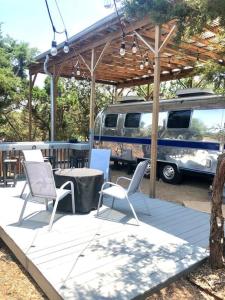 奥斯汀The Steel Magnolia Airstream - Cabins At Rim Rock的庭院配有桌椅和面包车。