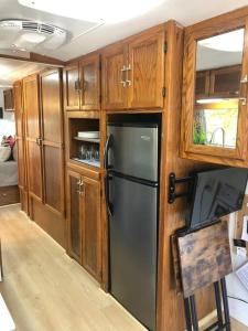 奥斯汀The Steel Magnolia Airstream - Cabins At Rim Rock的厨房配有黑色冰箱和木制橱柜。