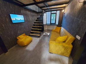 第比利斯The Passenger Rooms的客厅设有黄色沙发和楼梯。