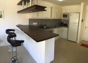 埃斯特角城Green Park Hermosos Apartamentos Vista al Lago的厨房配有白色橱柜和黑色台面