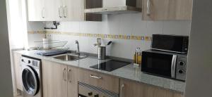 罗塔Apartamentos Costa de la Luz playa的厨房配有水槽和微波炉