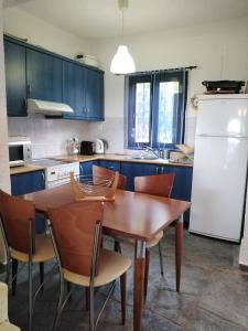希维利Rebekka's Guest House Elani的厨房配有桌椅和白色冰箱。