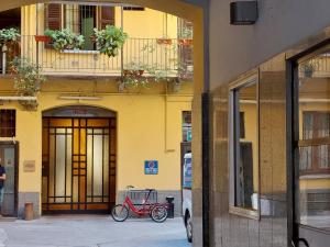 米兰2 Via Fabio Mangone的停在黄色建筑前面的一辆红色自行车