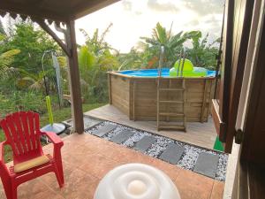 勒拉芒坦Magnifique Lodge en bois avec piscine et jardin de 800 m2的一个带热水浴缸和红色椅子的庭院