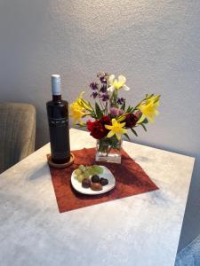 TannenbergFerienwohnung Rotbuche的一张桌子,上面放着一瓶葡萄酒和一瓶鲜花