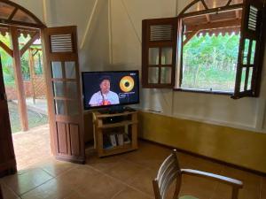 勒拉芒坦Magnifique Lodge en bois avec piscine et jardin de 800 m2的窗户间里配有电视