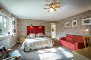 鲁特姆美丽女佣住宿加早餐旅馆的一间卧室配有一张床和一张红色的沙发
