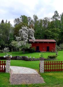 FinnerödjaStunning Tiny House Tree of Life at lake Skagern的院子中间的红色棚子,有栅栏