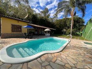 伊塔蒂亚亚Casa de Campo em Penedo - RJ的房屋前的游泳池