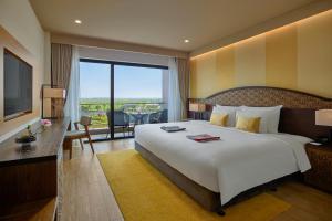 顺化KOBI Onsen Resort Hue的酒店客房设有一张大床和一个阳台。