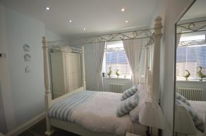 滨海纽比金Sandridge的一间卧室设有天蓬床和2个窗户