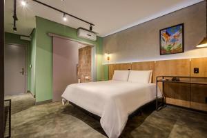 蓬塔格罗萨Slaviero Ponta Grossa的卧室设有一张白色大床和绿色的墙壁