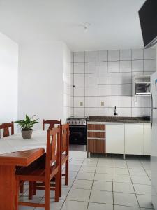 瓜尔达恩巴Pousada Figueira的厨房配有桌椅和冰箱。