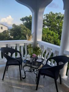 拉纳韦贝Hill view Vacational Rental的阳台配有两把椅子和一张鲜花桌子。