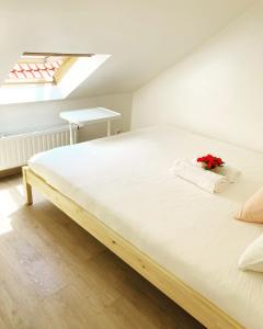 布鲁塞尔Benny's Rooms Brussels City Centre的一间卧室配有一张白色大床,床上有鲜花