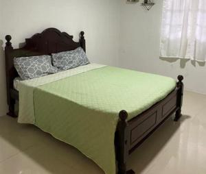 乔治敦Charming 1-Bed House in Georgetown的一间卧室配有一张带绿色棉被的床