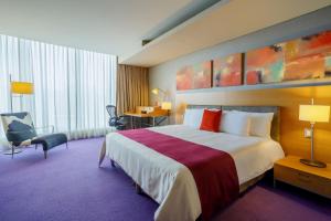 墨西哥城卡米诺里尔圣塔菲酒店的一间酒店客房,设有一张大床和一个大窗户