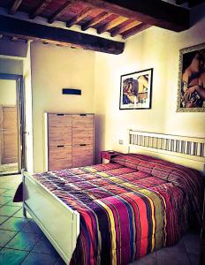 卢奇尼亚诺La Dormeuse的一间卧室配有一张带彩色毯子的床