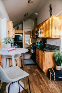 奥斯汀The Bison Cabin - The Cabins at Rim Rock的厨房配有木制橱柜和桌椅