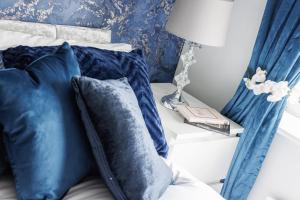 北安普敦Home From Home Northampton的一张带蓝色枕头的床和一张带台灯的桌子