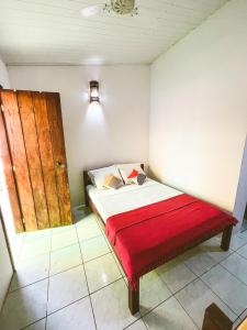 伊塔卡雷Buddy's Hostel Itacaré的小房间,配有一张带红色毯子的床